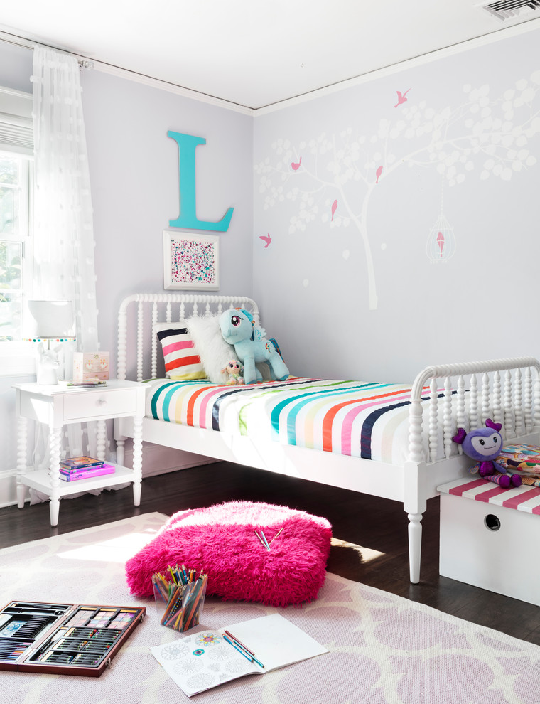 Cette photo montre une grande chambre tendance avec un mur violet, parquet foncé et un sol marron.