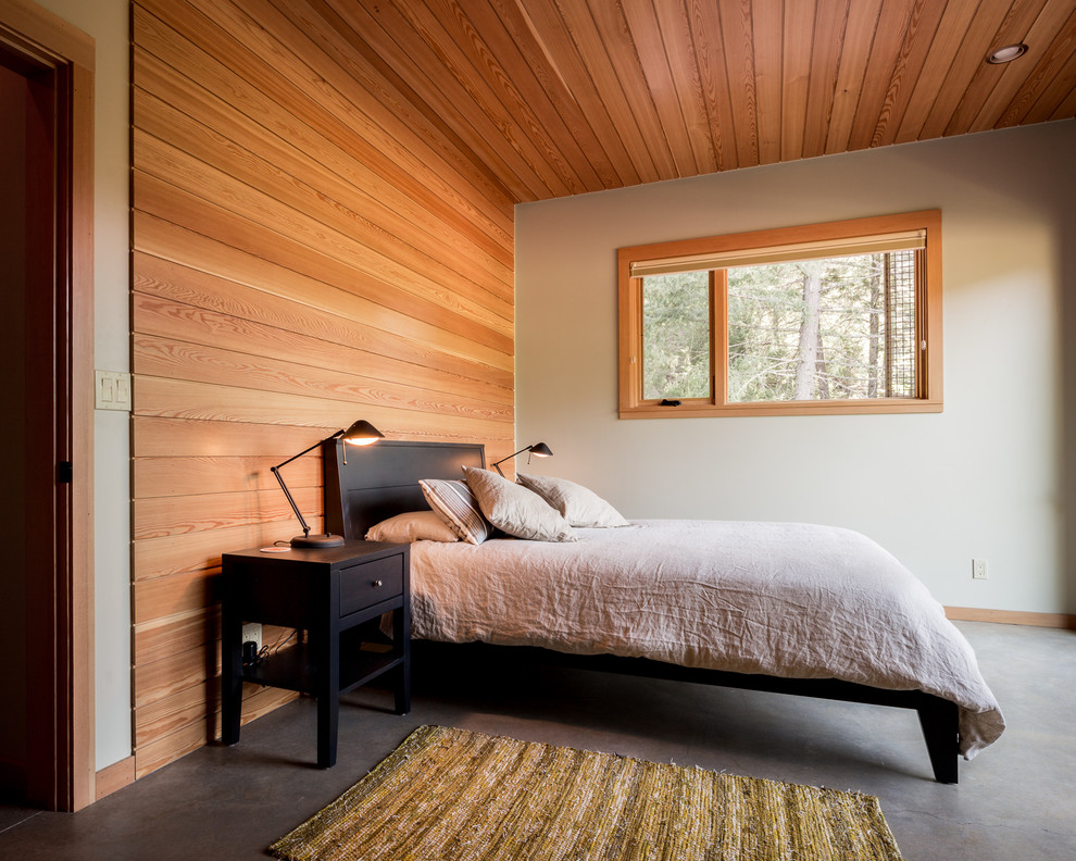 Großes Modernes Hauptschlafzimmer ohne Kamin mit weißer Wandfarbe und Betonboden in Seattle