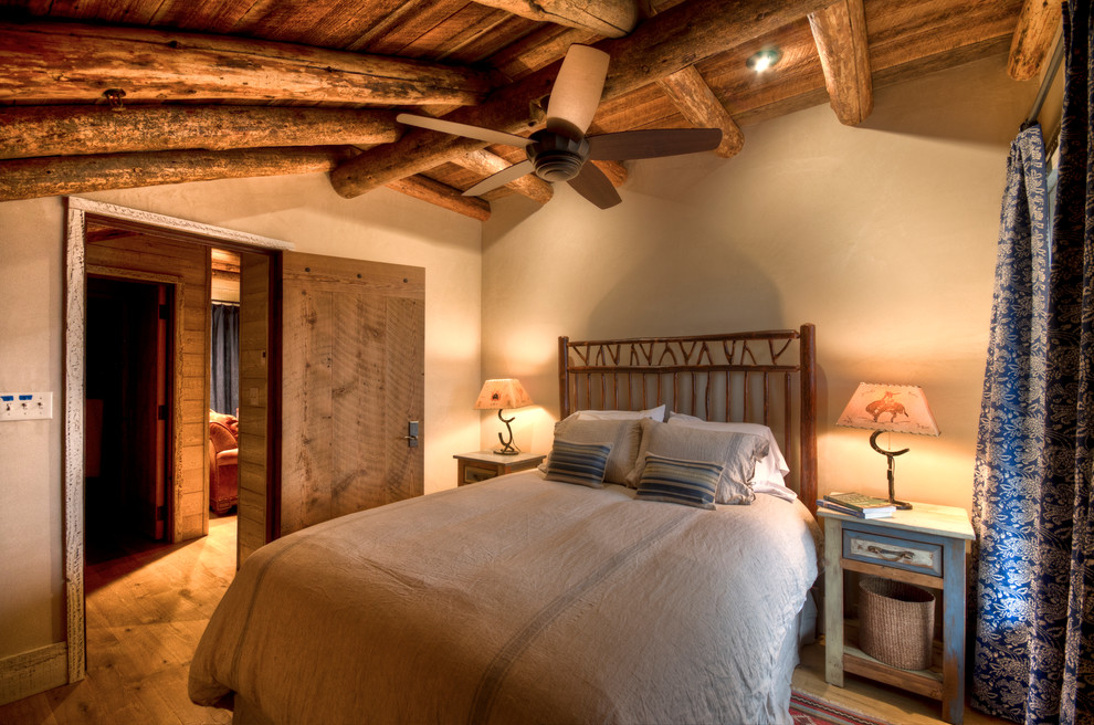 Ejemplo de habitación de invitados tradicional de tamaño medio con paredes beige y suelo de madera clara