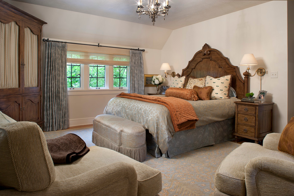 Réalisation d'une grande chambre parentale tradition avec un mur beige, un sol en bois brun et aucune cheminée.