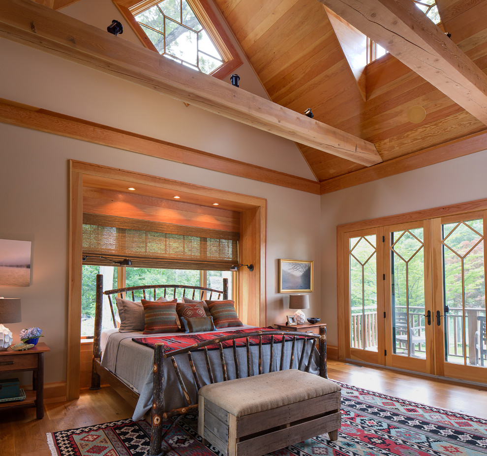 Foto de dormitorio principal rústico grande sin chimenea con paredes marrones, suelo de madera en tonos medios y suelo marrón