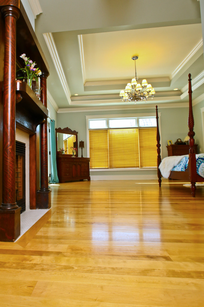 Modelo de dormitorio principal de estilo americano grande con paredes verdes, suelo de madera clara y todas las chimeneas