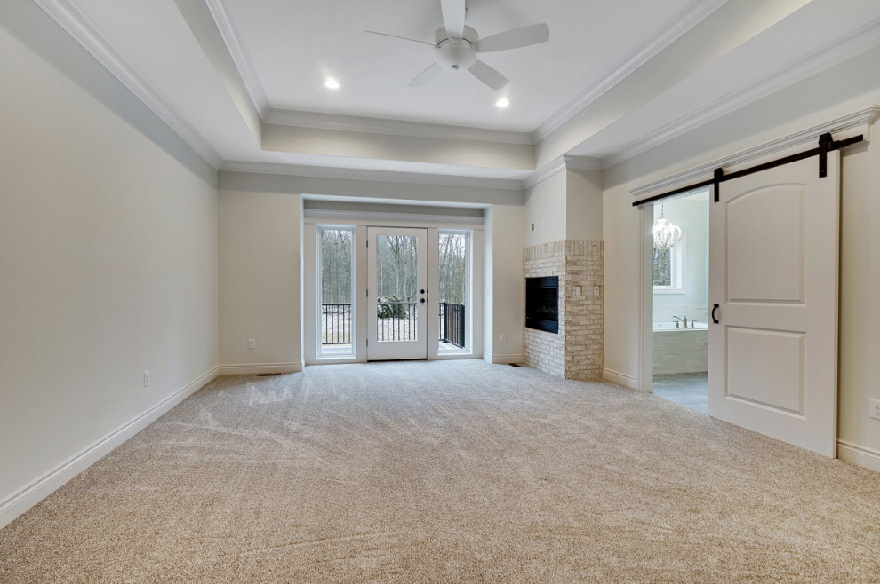 Inspiration for a large timeless master carpeted and beige floor bedroom remodel in Detroit with beige walls, a corner fireplace and a brick fireplace