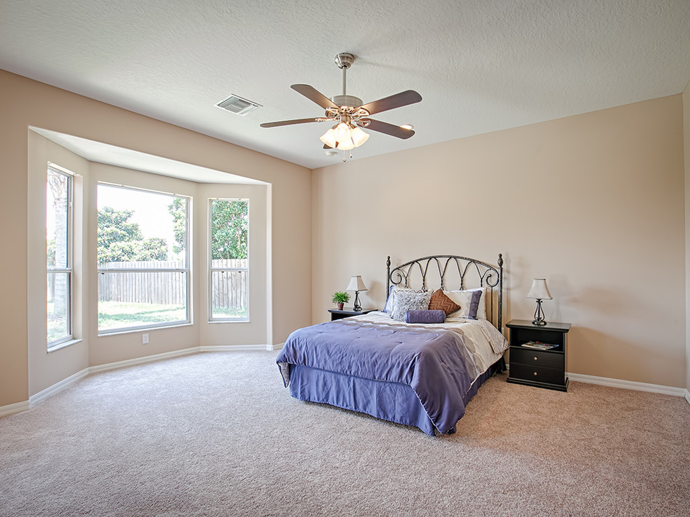 Ejemplo de dormitorio principal tradicional de tamaño medio sin chimenea con paredes beige y moqueta