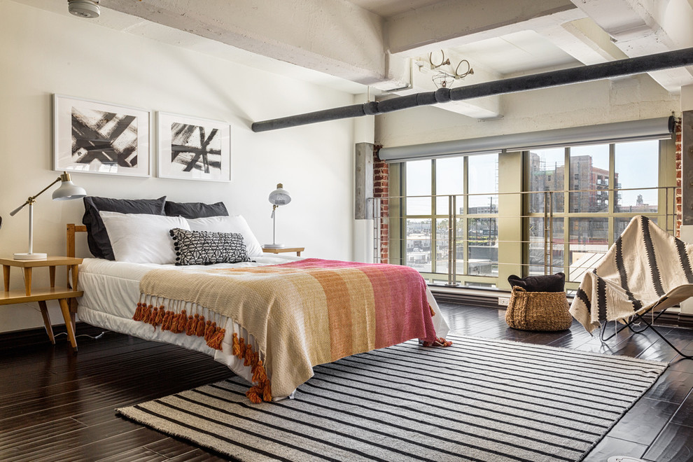 Ejemplo de dormitorio urbano con paredes blancas, suelo de madera oscura y suelo marrón