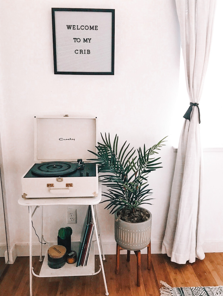 Idées déco pour une petite chambre d'amis rétro avec un mur blanc, parquet en bambou et un sol marron.