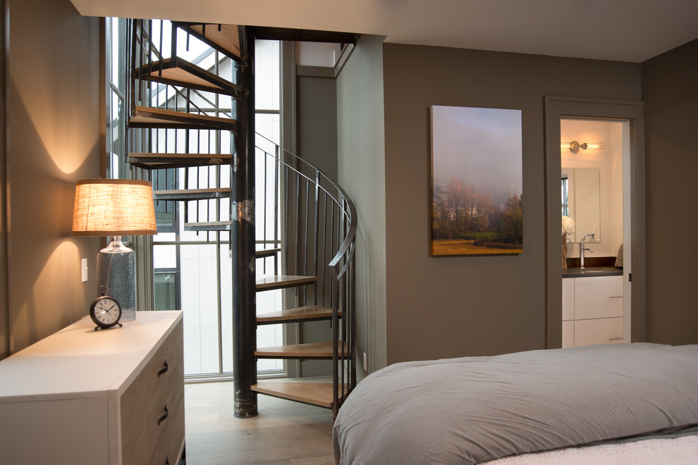 Ejemplo de dormitorio principal contemporáneo pequeño con paredes grises y suelo de madera clara