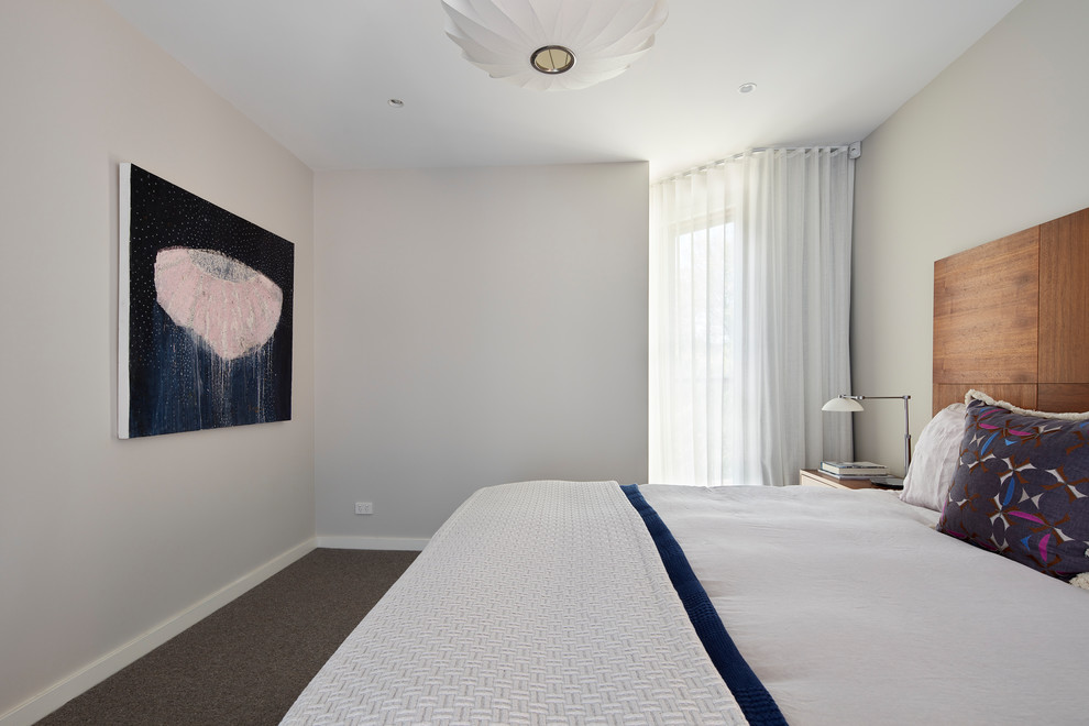 Example of a mid-sized trendy carpeted and brown floor bedroom design in Canberra - Queanbeyan with white walls and no fireplace