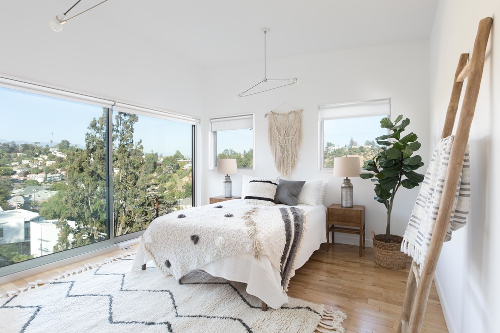 Maritimes Hauptschlafzimmer mit weißer Wandfarbe, hellem Holzboden und beigem Boden in Los Angeles