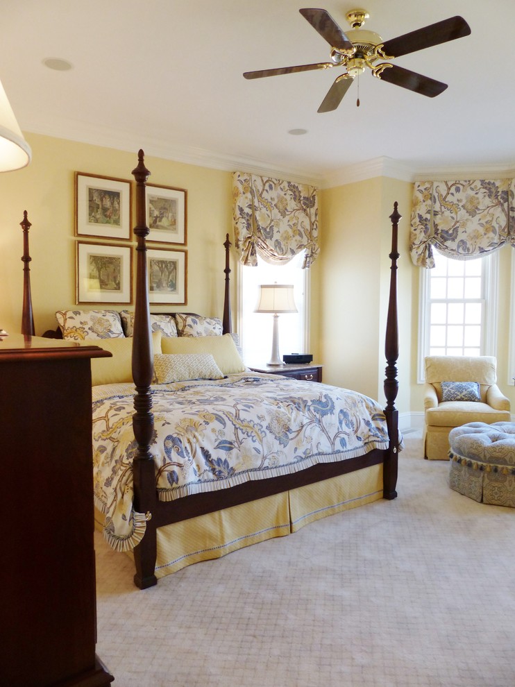 This is an example of a large classic master bedroom in Columbus with yellow walls and carpet.