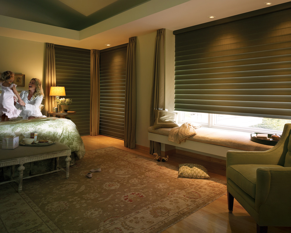Modelo de dormitorio principal clásico de tamaño medio con paredes verdes y suelo de madera clara