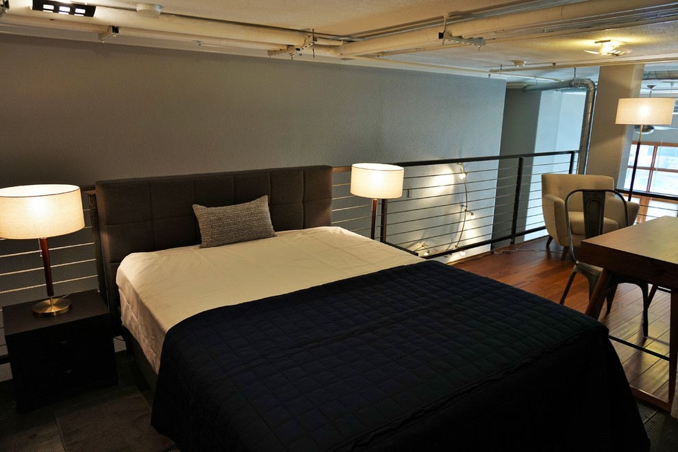 Idee per una piccola camera da letto stile loft moderna con pareti grigie, pavimento in legno massello medio e pavimento arancione