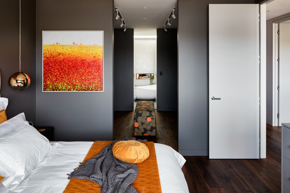Immagine di una camera da letto minimal con pareti grigie, parquet scuro e pavimento marrone