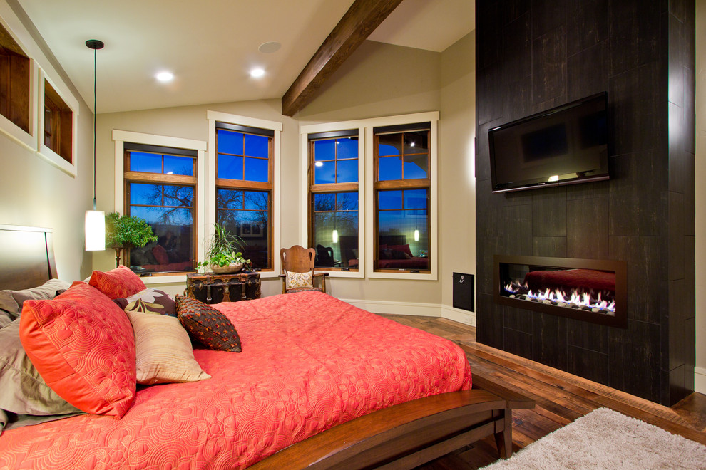 Foto de dormitorio de estilo americano con paredes beige, suelo de madera en tonos medios, chimenea lineal y marco de chimenea de baldosas y/o azulejos