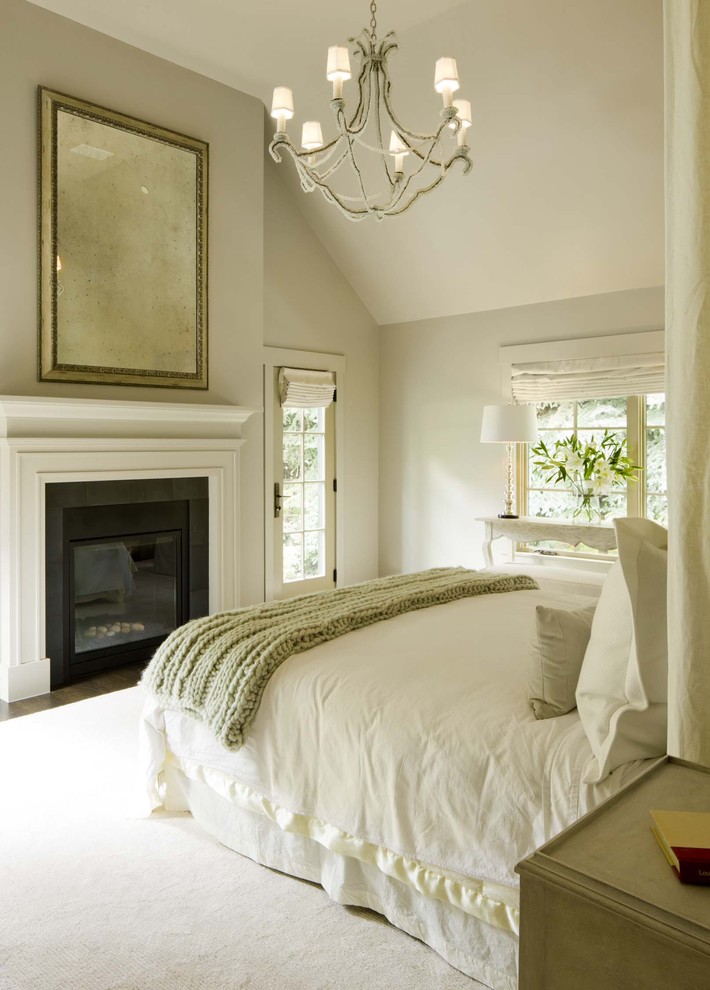 Стильный дизайн: спальня в стиле неоклассика (современная классика) с бежевыми стенами и стандартным камином - последний тренд