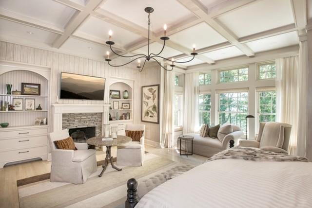 Источник вдохновения для домашнего уюта: большая хозяйская спальня в классическом стиле с белыми стенами, светлым паркетным полом, стандартным камином и фасадом камина из дерева