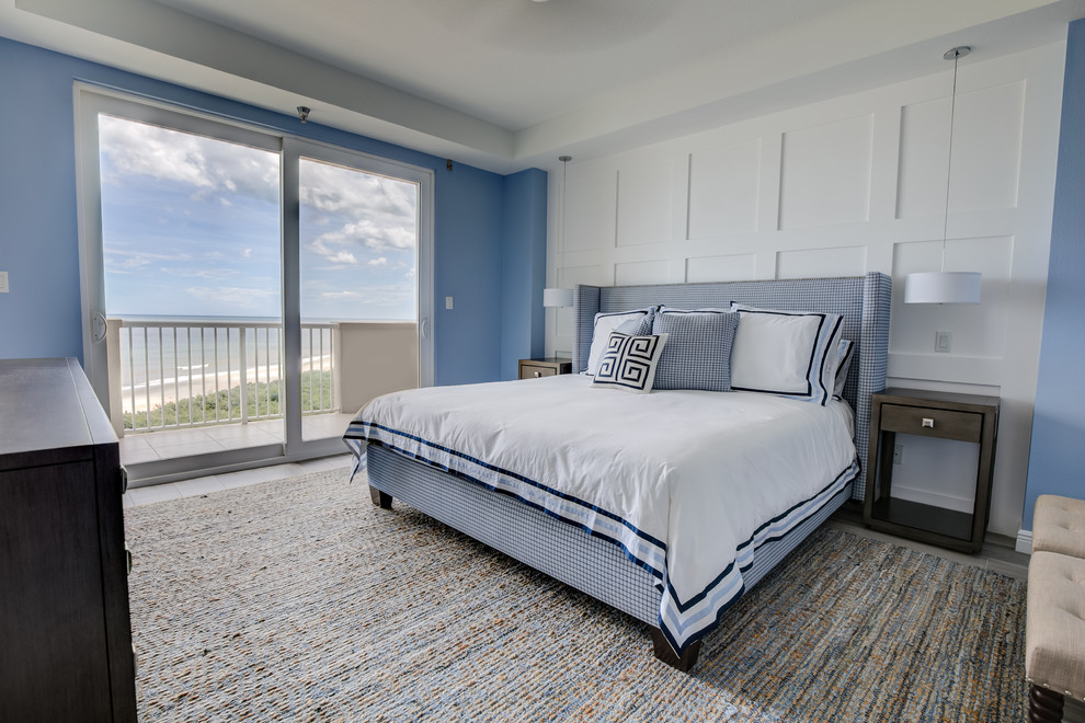 オーランドにある中くらいなビーチスタイルのおしゃれな主寝室 (青い壁、磁器タイルの床、ベージュの床) のインテリア