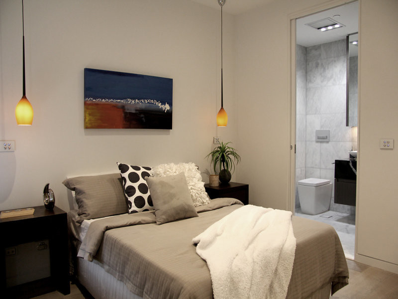 Photo of a small contemporary bedroom in Melbourne with white walls and light hardwood flooring.