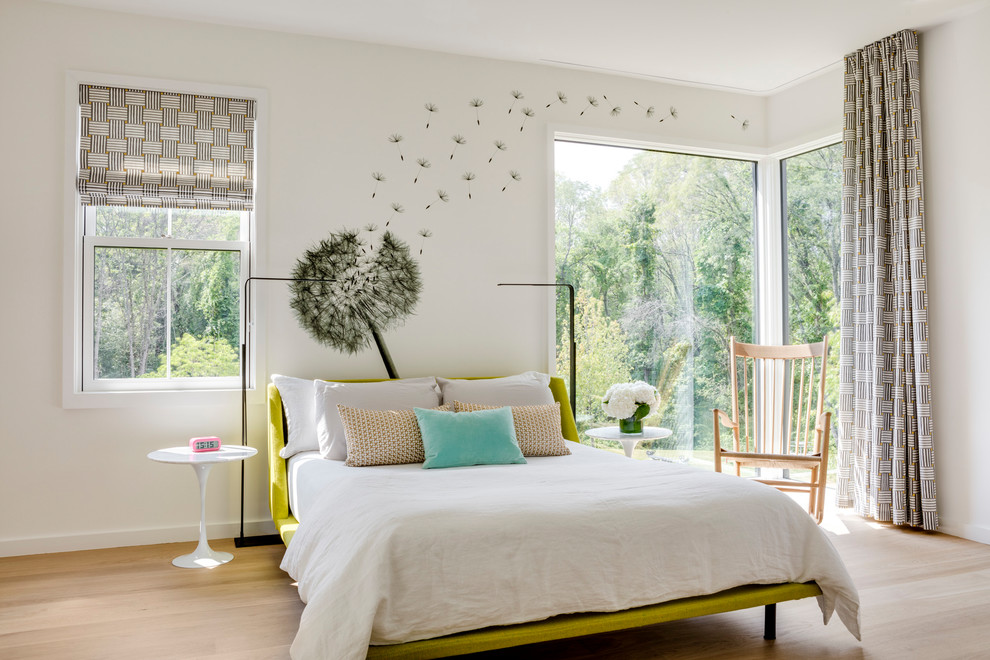Ejemplo de habitación de invitados actual de tamaño medio sin chimenea con paredes blancas, suelo de madera clara y suelo beige