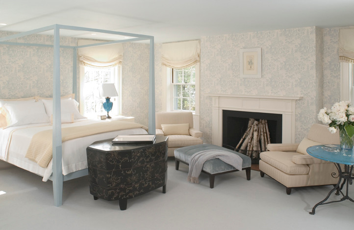На фото: хозяйская спальня среднего размера в классическом стиле с синими стенами, ковровым покрытием, стандартным камином, фасадом камина из дерева и коричневым полом