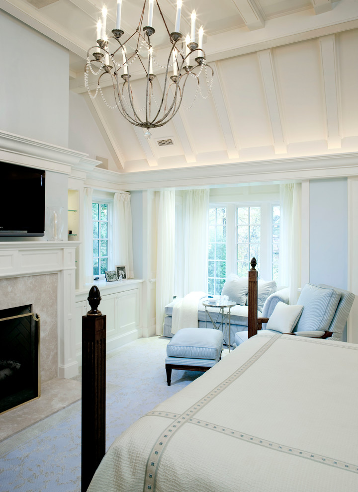 На фото: хозяйская спальня среднего размера в классическом стиле с синими стенами, ковровым покрытием, стандартным камином, фасадом камина из камня, бежевым полом и телевизором с