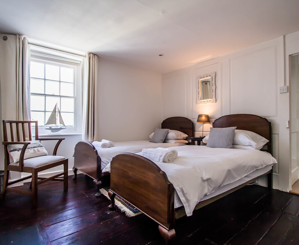 На фото: большая гостевая спальня (комната для гостей) в современном стиле с белыми стенами и темным паркетным полом с