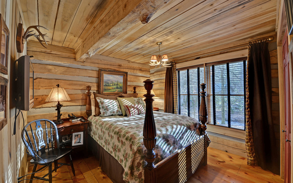 Immagine di una camera da letto rustica con pavimento in legno massello medio