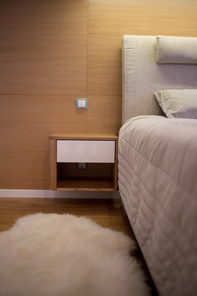 Ispirazione per una piccola camera matrimoniale design con pavimento in legno massello medio