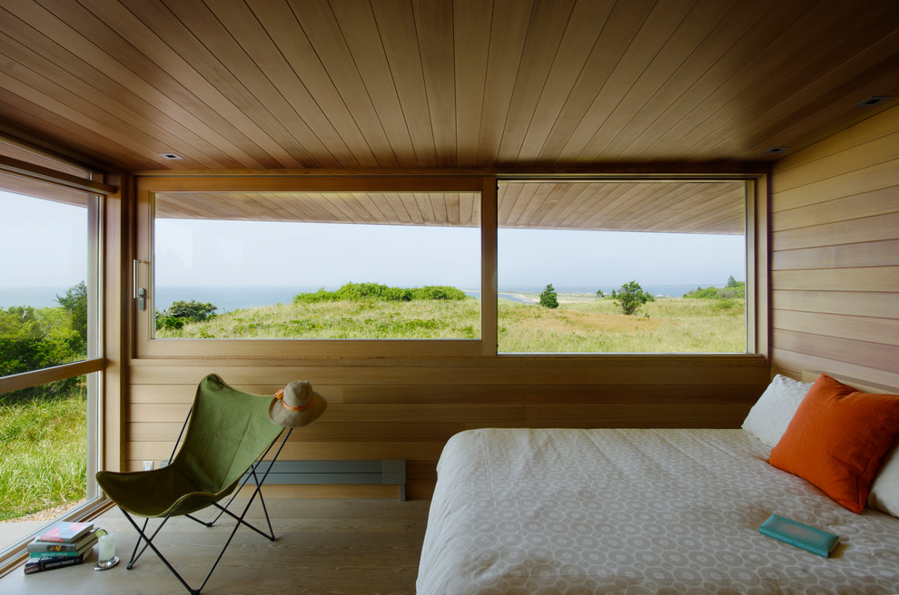 Idéer för ett modernt sovrum, med mellanmörkt trägolv