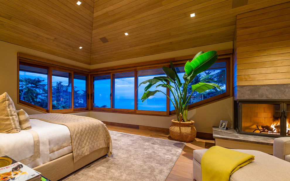 Hauptschlafzimmer mit braunem Holzboden und Eckkamin in Santa Barbara