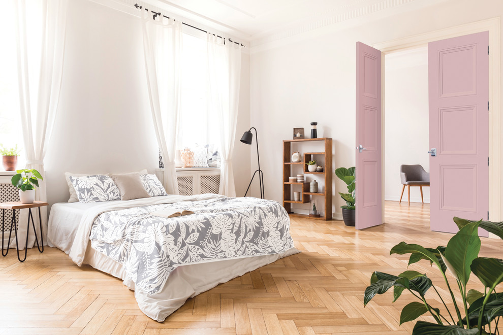 Diseño de dormitorio ecléctico grande sin chimenea con paredes blancas, suelo de madera clara y suelo marrón