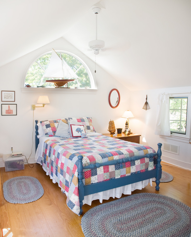 Diseño de habitación de invitados tradicional de tamaño medio con paredes blancas, suelo de madera en tonos medios y techo inclinado