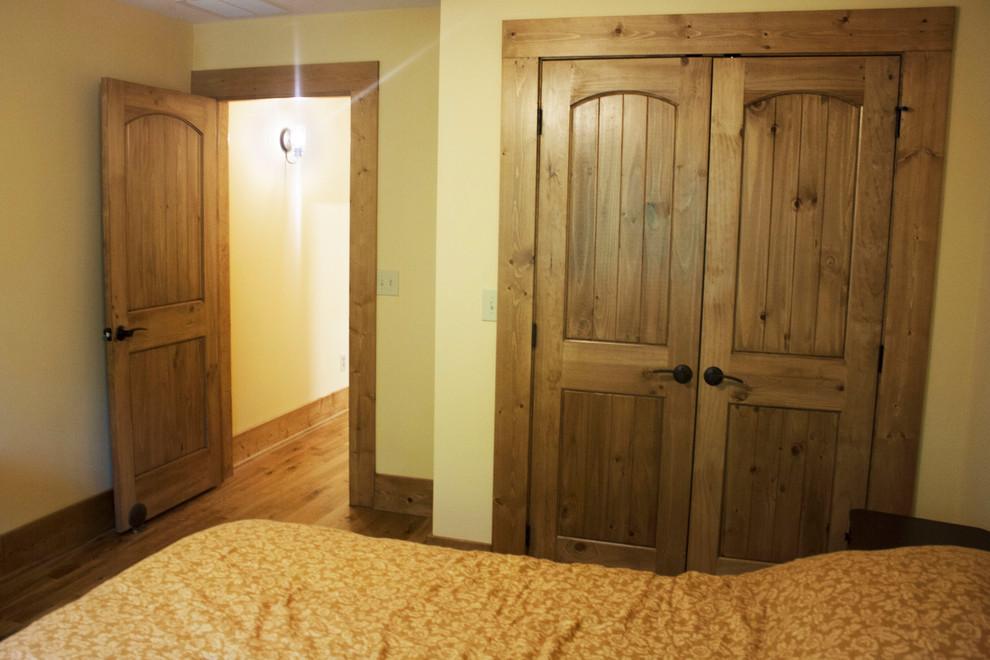 Aménagement d'une grande chambre d'amis montagne avec un mur beige, parquet foncé et un sol multicolore.