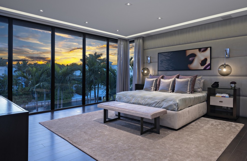 Diseño de dormitorio actual grande con paredes grises y suelo de madera en tonos medios