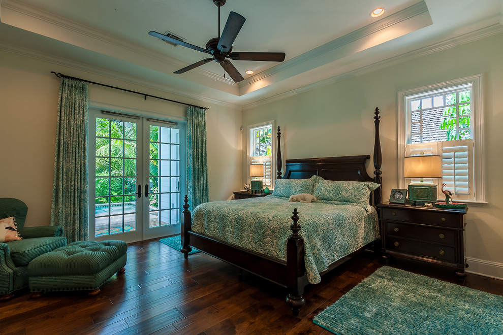 Large nautical master bedroom in Miami with dark hardwood flooring, no fireplace, beige walls and brown floors.