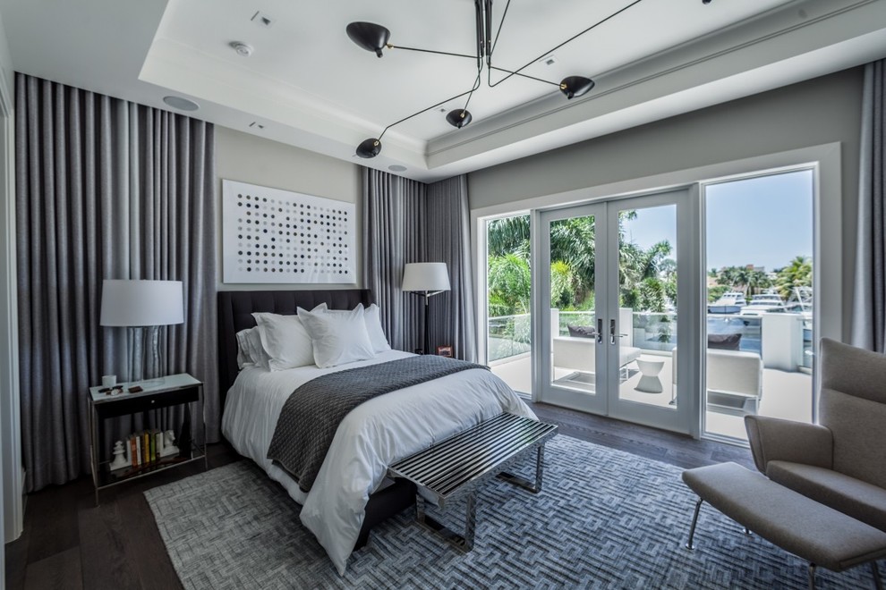 Contemporary grey and silver bedroom in New York with grey walls and dark hardwood flooring.