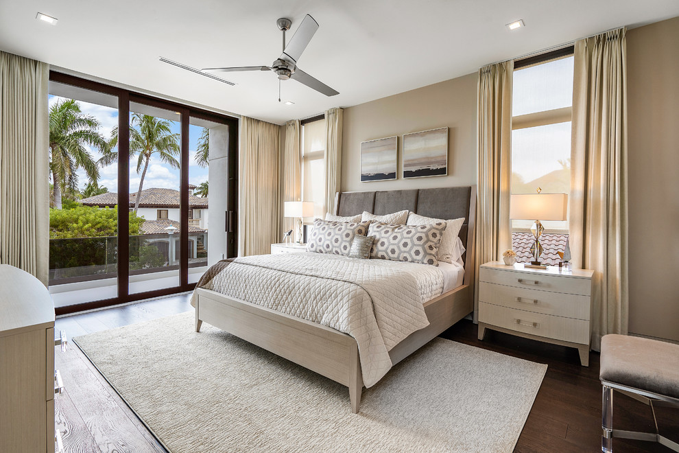 Modelo de dormitorio principal minimalista grande con paredes beige, suelo de madera en tonos medios y suelo marrón
