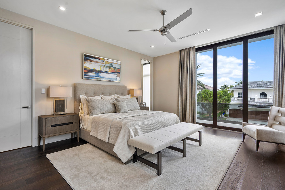 Example of a large minimalist master medium tone wood floor and brown floor bedroom design in Miami with beige walls