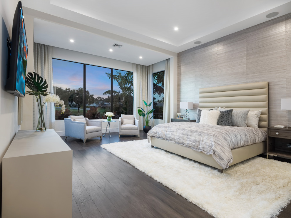 Modernes Schlafzimmer mit grauer Wandfarbe, dunklem Holzboden, braunem Boden, Tapetenwänden und eingelassener Decke in Miami