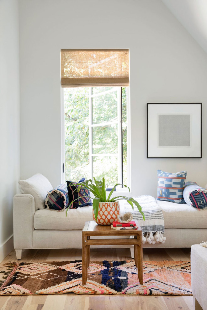 Photo of a bohemian bedroom in Minneapolis with white walls and light hardwood flooring.