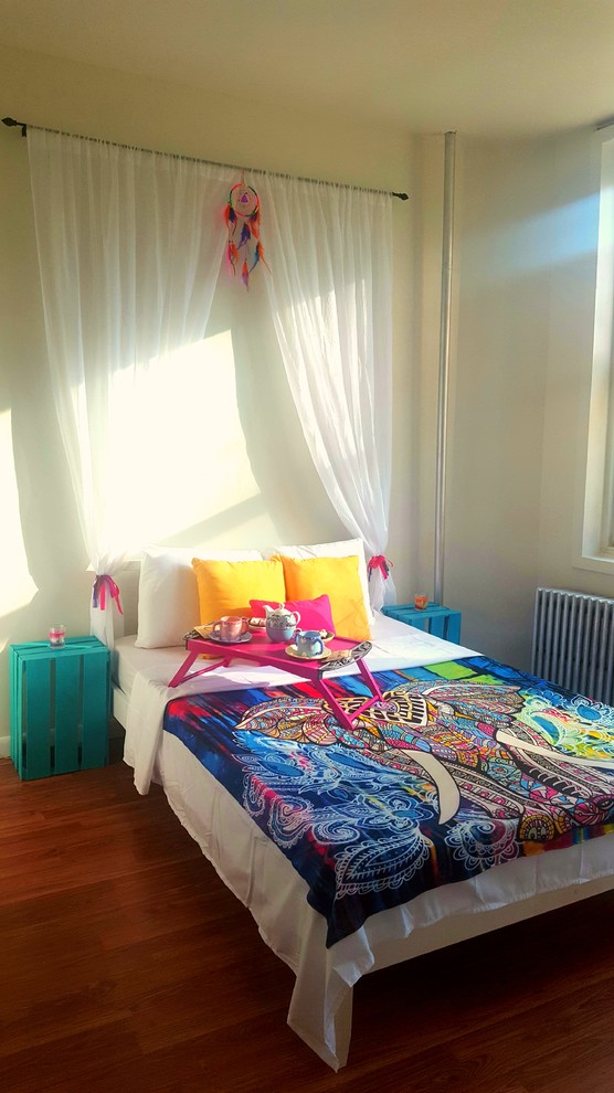 На фото: гостевая спальня (комната для гостей) в стиле фьюжн с белыми стенами и полом из ламината с