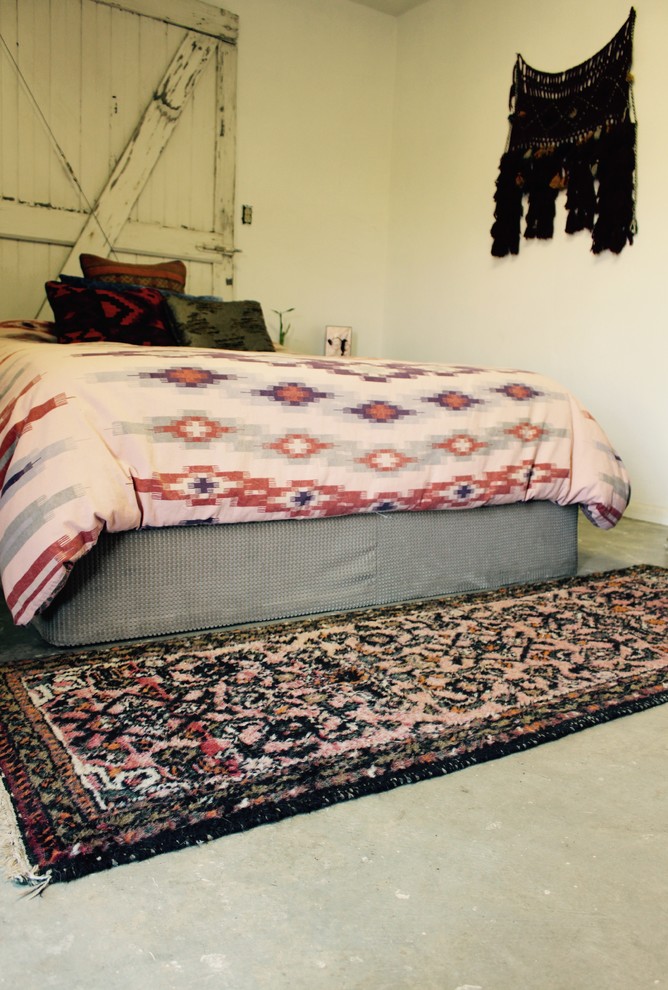 На фото: маленькая хозяйская спальня в средиземноморском стиле с белыми стенами и бетонным полом без камина для на участке и в саду