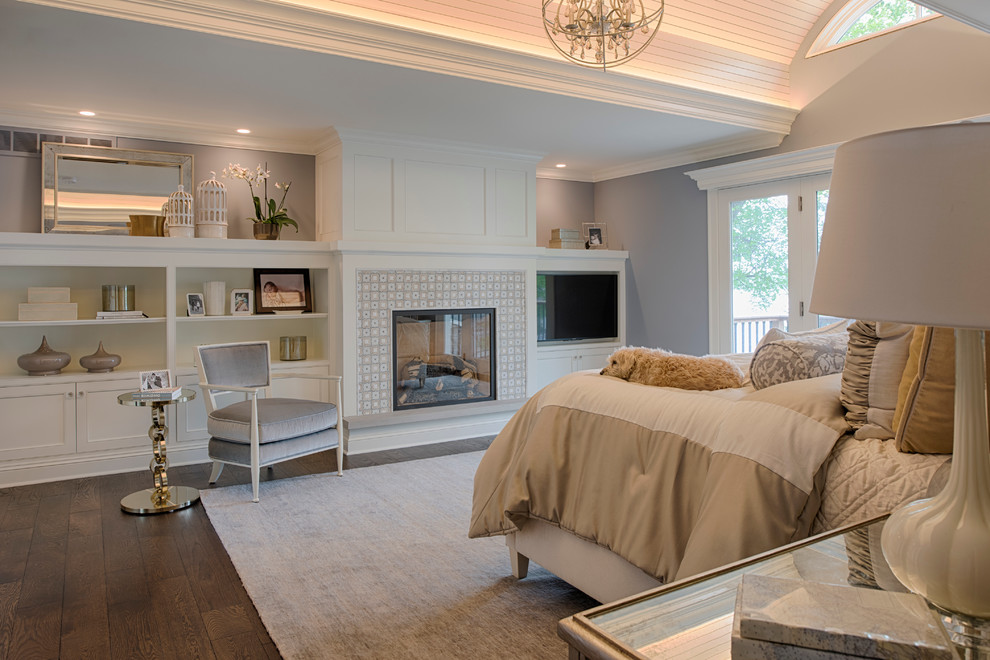 ミネアポリスにある中くらいなトランジショナルスタイルのおしゃれな主寝室 (グレーの壁、濃色無垢フローリング、標準型暖炉、タイルの暖炉まわり、茶色い床、グレーとブラウン) のレイアウト