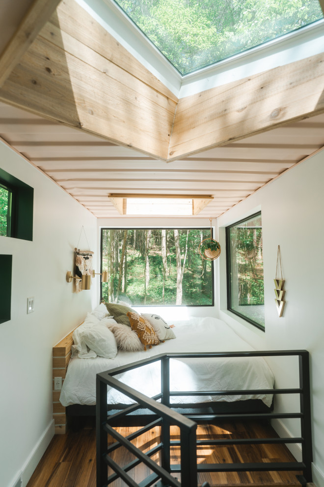 Landhaus Schlafzimmer im Dachboden mit weißer Wandfarbe, dunklem Holzboden, braunem Boden und Holzdecke in Kolumbus