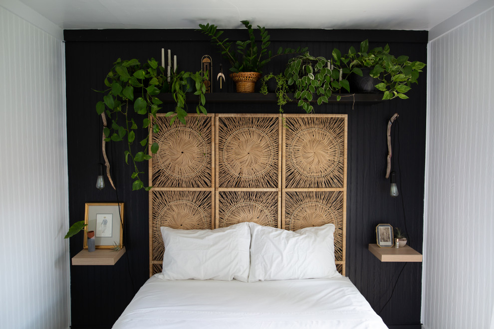 Diseño de dormitorio principal nórdico pequeño sin chimenea con paredes negras, suelo laminado, suelo beige y panelado