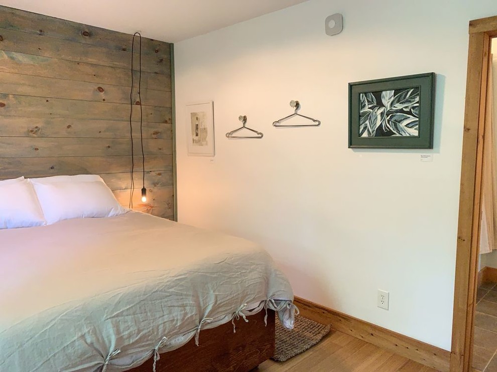 Ejemplo de dormitorio de estilo de casa de campo pequeño sin chimenea con paredes blancas, suelo de madera clara y suelo beige