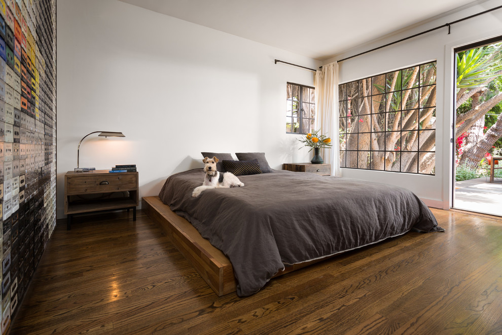 Exemple d'une chambre parentale tendance de taille moyenne avec un mur blanc, un sol marron, aucune cheminée et un sol en bois brun.