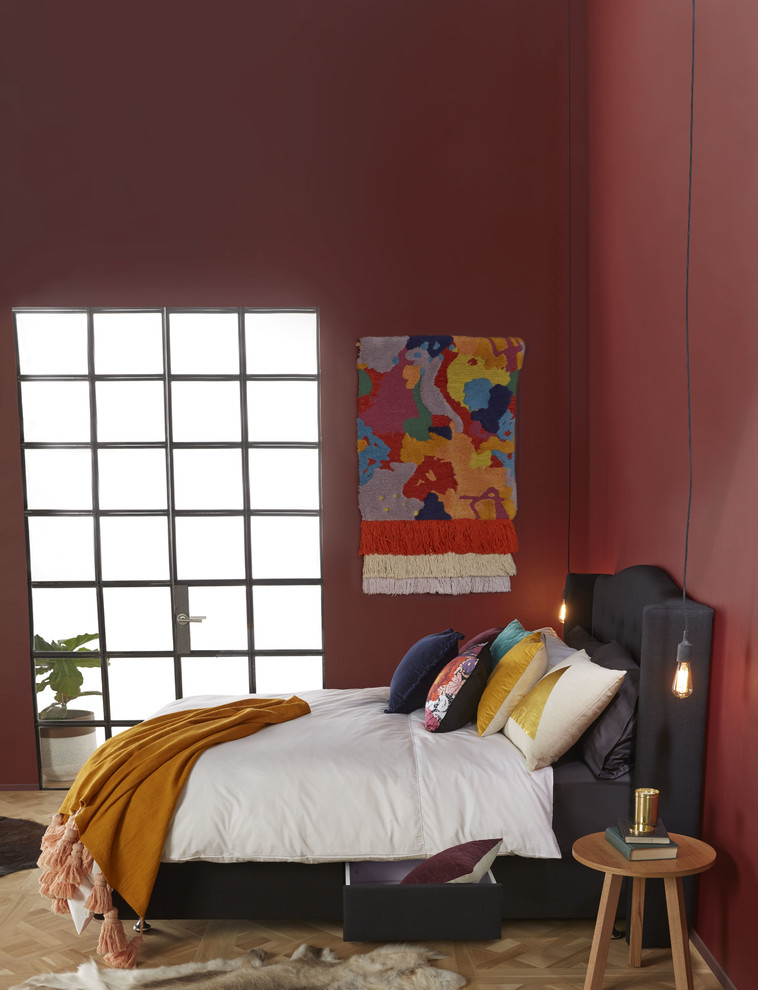 Bild på ett mellanstort funkis gästrum, med röda väggar och ljust trägolv