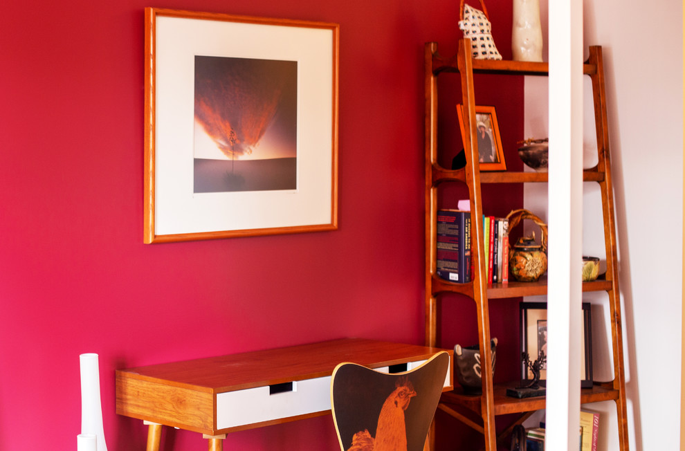 Foto de dormitorio principal actual de tamaño medio sin chimenea con paredes rojas, suelo de madera en tonos medios y suelo marrón
