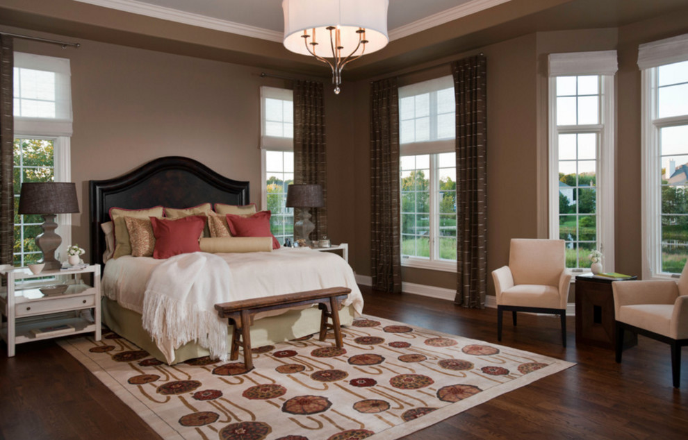 Design ideas for a large traditional master bedroom in Kansas City with beige walls, dark hardwood flooring and no fireplace.